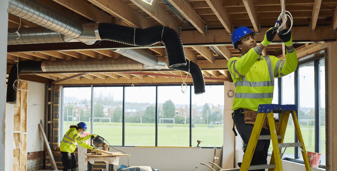 Electrical engineer installing wiring at precise points marked by a robotic layout solution