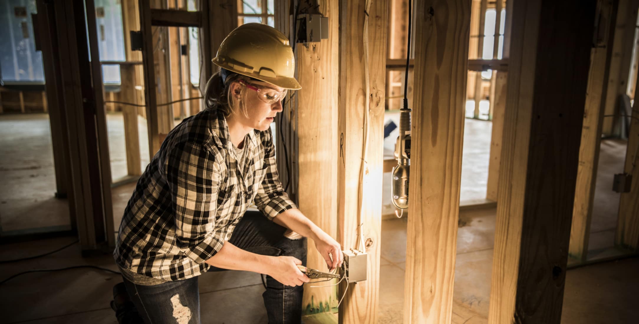 Electrician using different electrical construction tools to wire a residential build