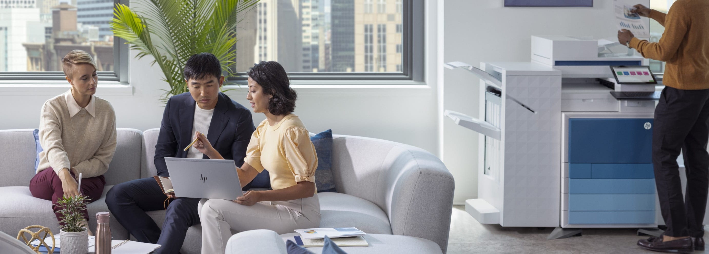 Professionals seated in office lobby, HP LaserJet Enterprise MFP behind them