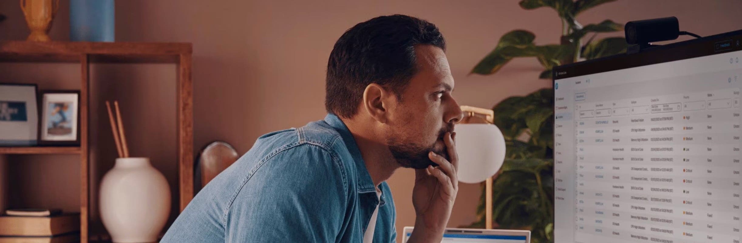 Man standing in front of desk working on his computer