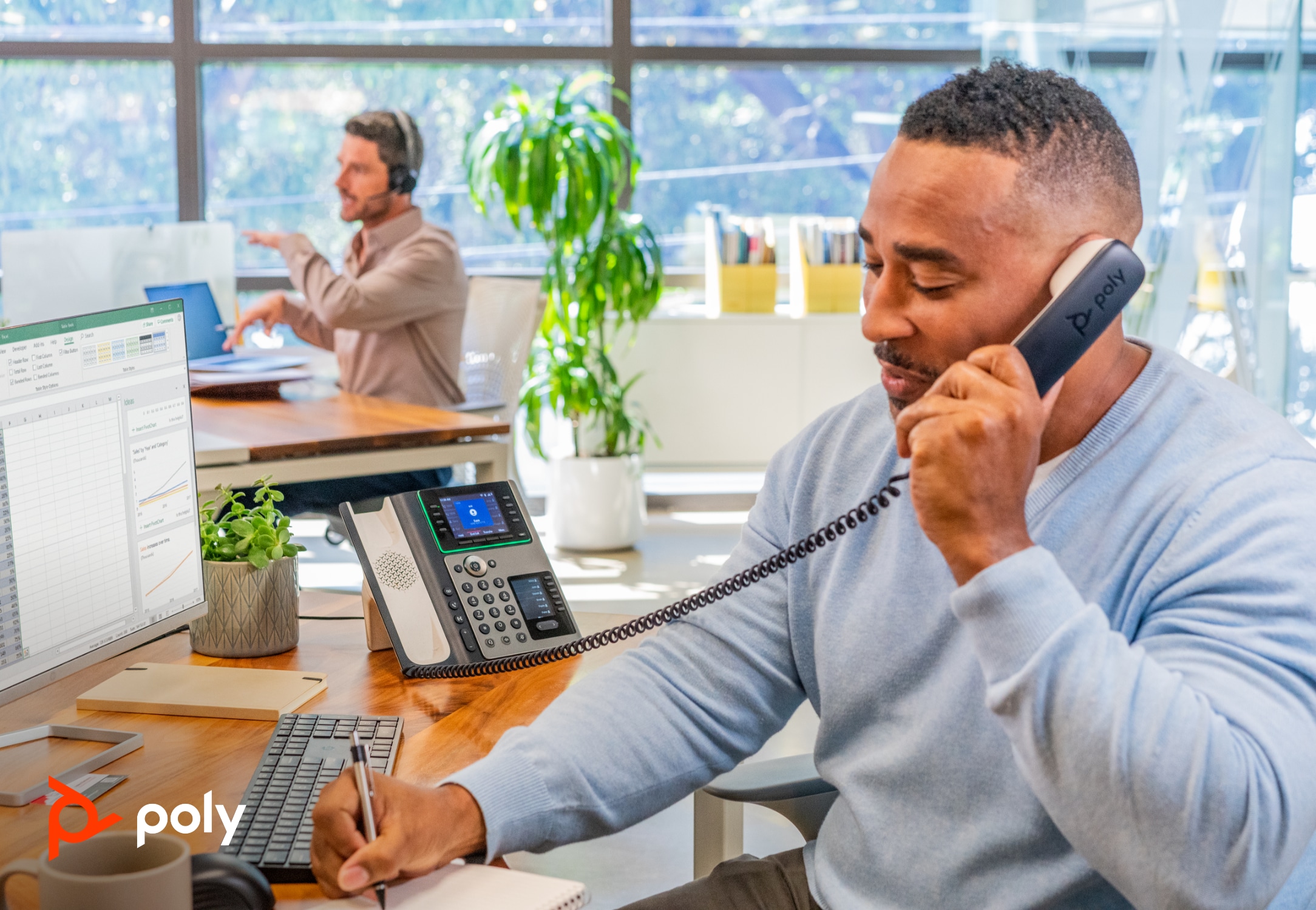 Man working in hybrid office using Poly phone and HP desktop