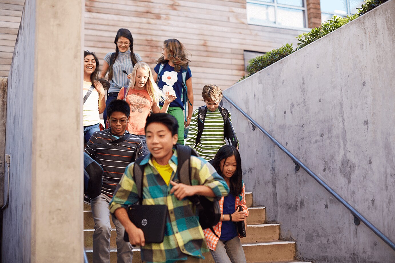 Children leaving school carrying HP laptops