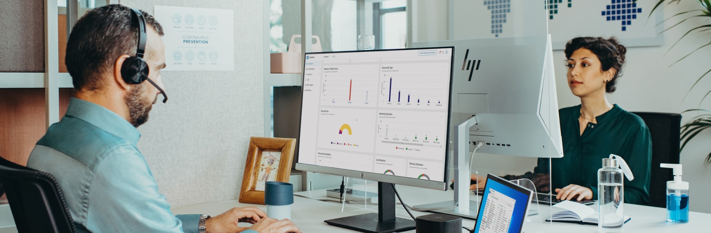 A man with a headset looking at an HP monitor that has an analytics dashboard on the screen