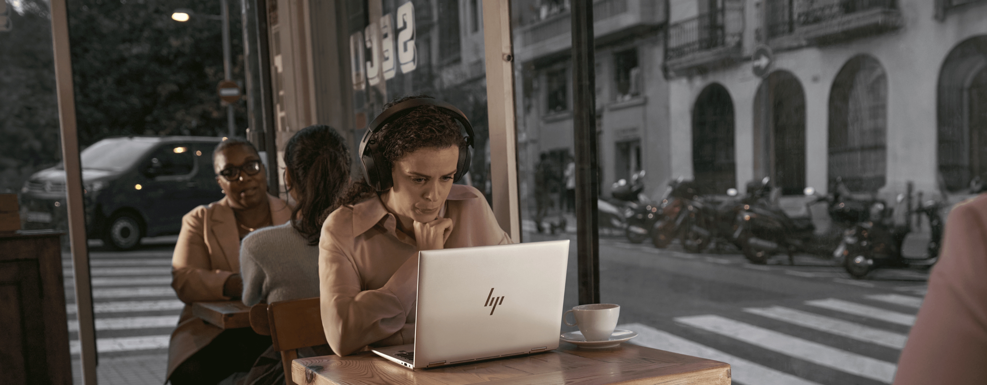 Woman working on an HP laptop in a coffee shop