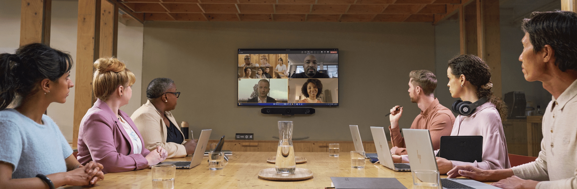 Coworkers at a conference table with HP laptop PCs.