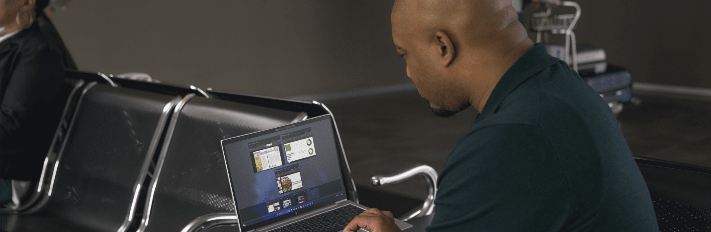 Man working on an HP laptop at an airport.