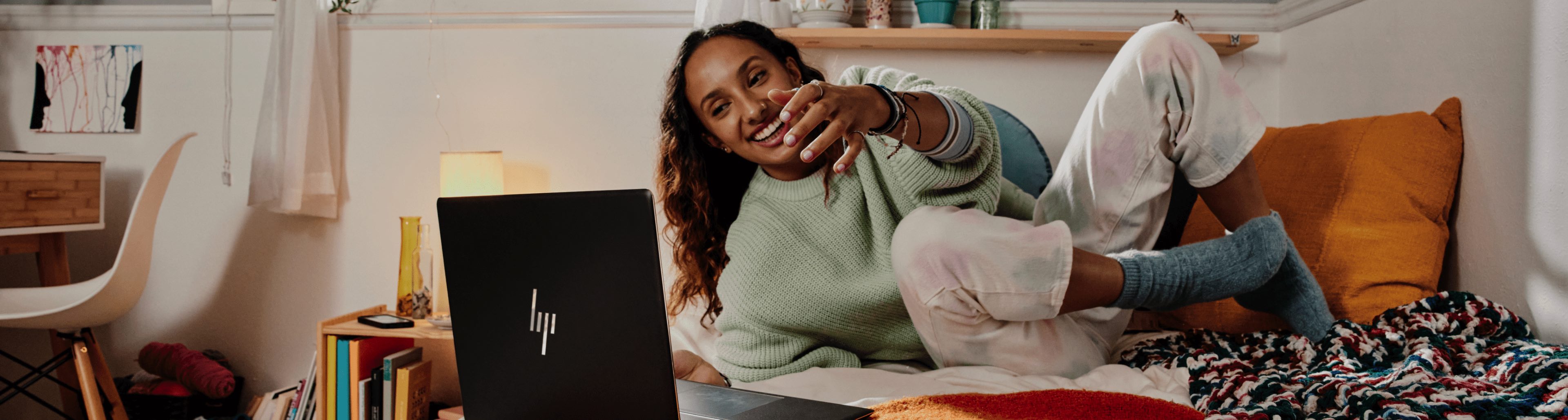 A woman in a bed staring at an HP Laptop