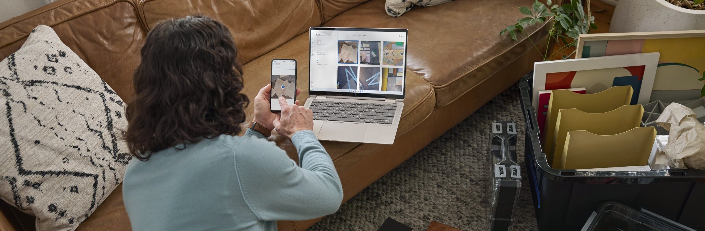 Man transferring photos from phone to laptop