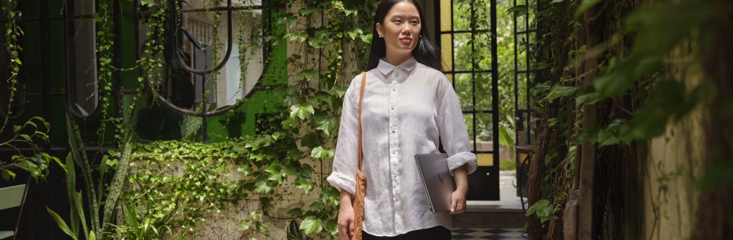 Woman carrying laptop and walking