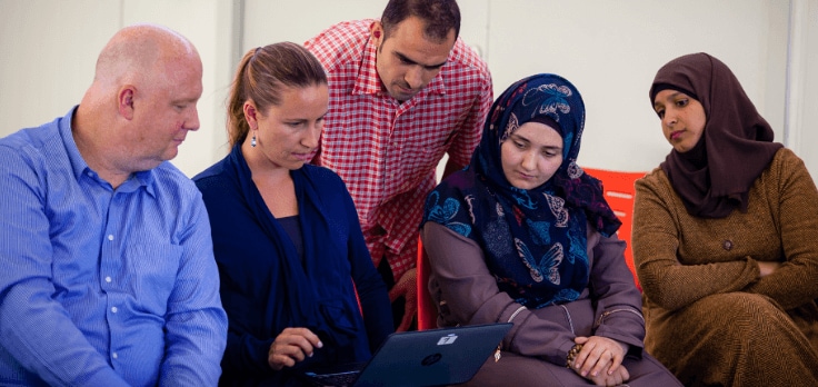 Group of people watching something on a tablet