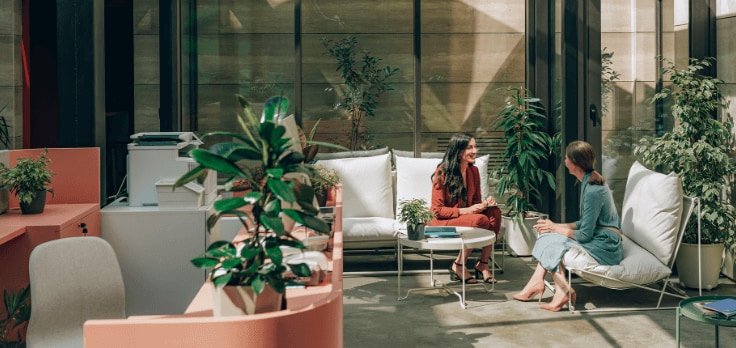 Two women talking to each other in a room.