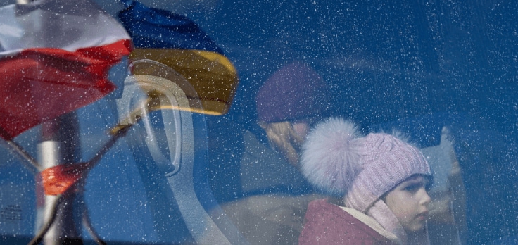 Photo of a mother with her daughter looking through a window