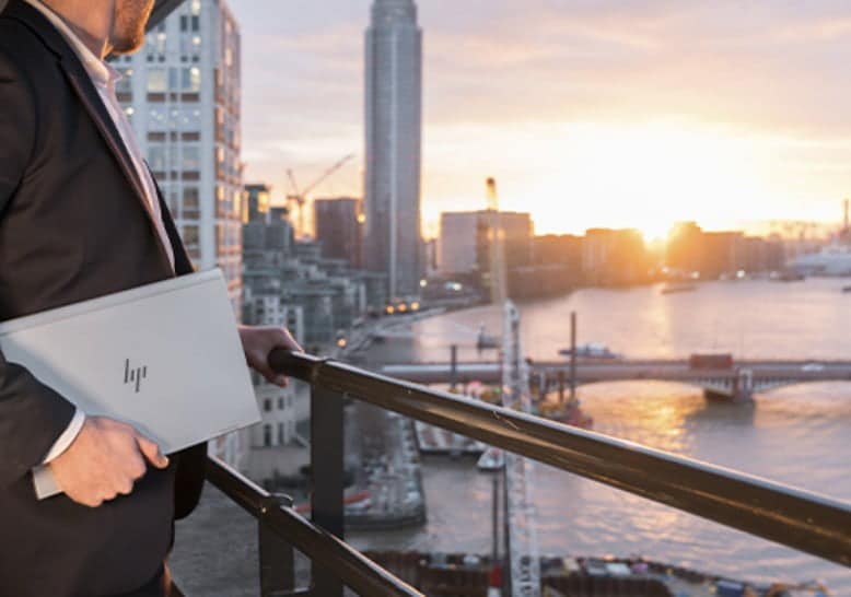 Man holding HP laptop, overlooking city line