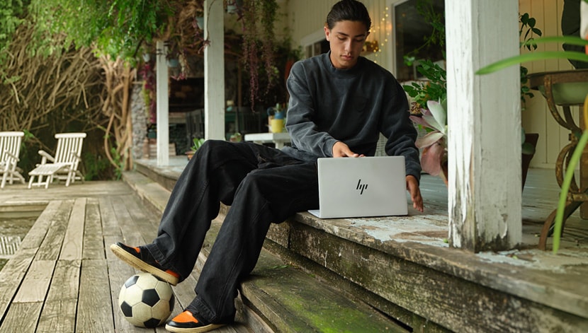 image of a boy with a soccer ball and HP laptop