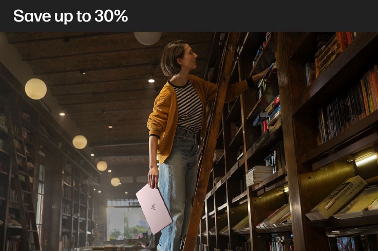 image of a lady on a library ladder with her laptop in her hand