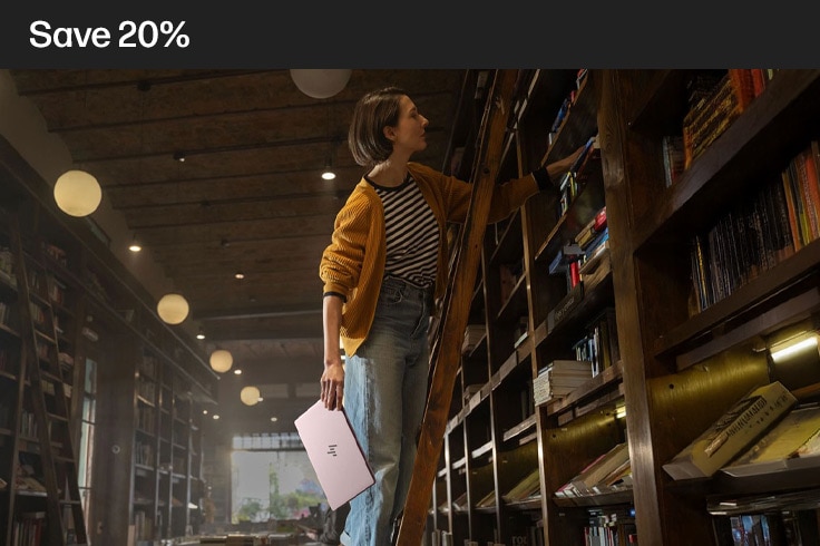 image of a lady on a library ladder with her laptop in her hand