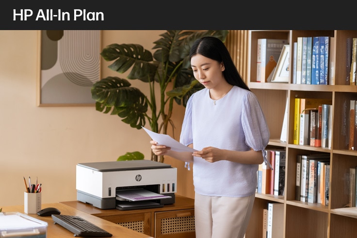 image of young woman standing by a AIO printer
