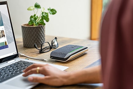 person having a meeting over the internet using a poly speakerphone