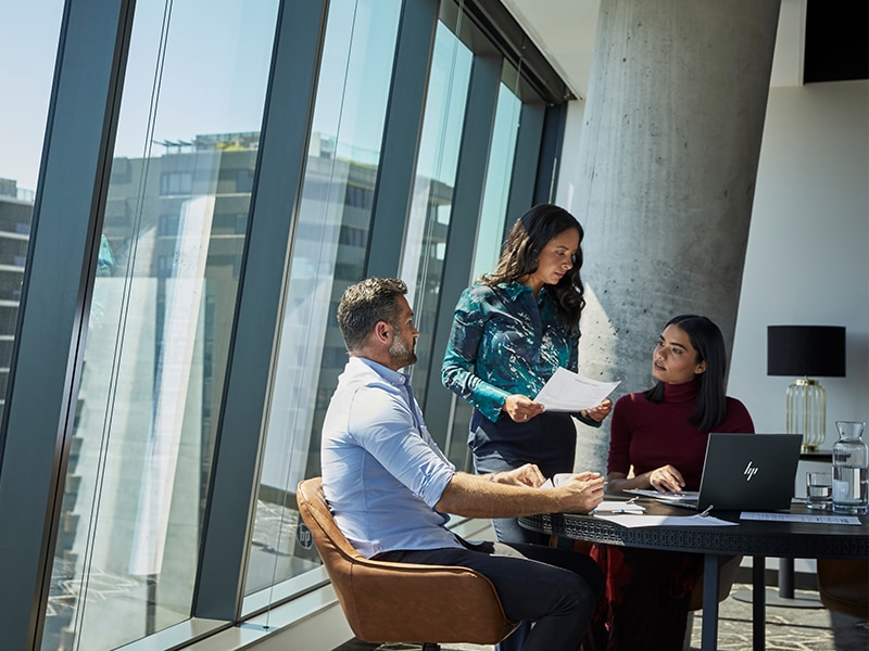 A work team discussing data while working on an HP Laptop