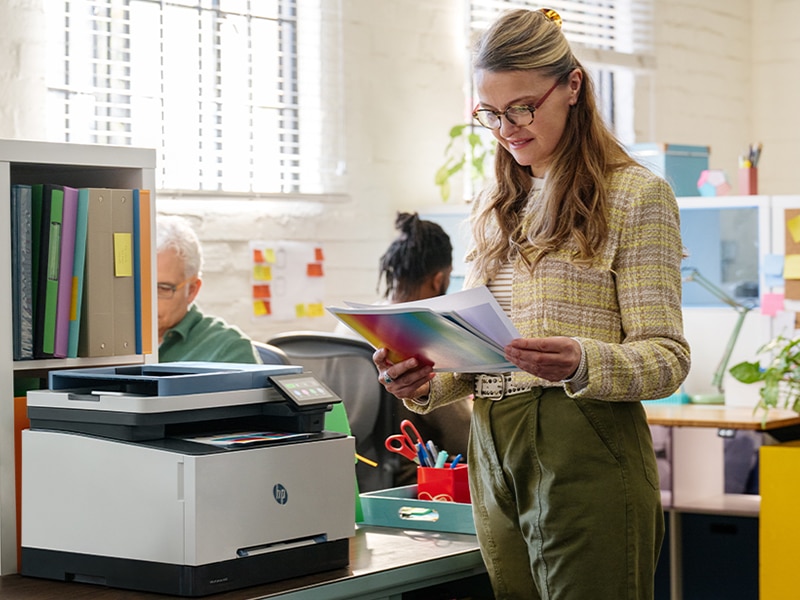 Lady reviewing documents printed on a HP LaserJet printer